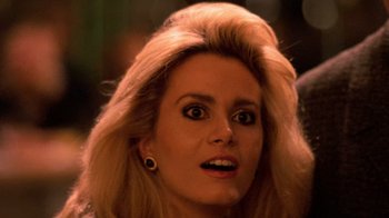 Movie still from “The Running Man” (1987), directed by Paul Michael Glaser – A person with blonde hair; Close Up shot, Over the shoulder angle