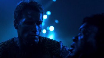 Movie still from “The Running Man” (1987), directed by Paul Michael Glaser – A man and a woman in a dark room; Close Up shot, Over the shoulder angle