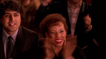 Movie still from “The Running Man” (1987), directed by Paul Michael Glaser – A woman smiling with her hair in the wind; Close Up shot, High angle