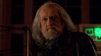 Movie still from “The Running Man” (1987), directed by Paul Michael Glaser – An old man with long white hair wearing a leather jacket; Close Up shot, Over the shoulder angle