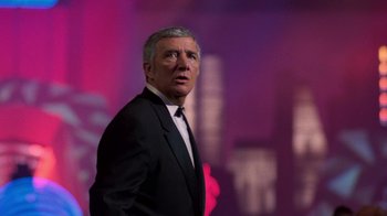 Movie still from “The Running Man” (1987), directed by Paul Michael Glaser – A person wearing a suit and tie; Medium shot, Low angle