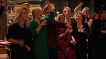 Movie still from “The Running Man” (1987), directed by Paul Michael Glaser – A group of people standing around each other; Medium shot, High angle