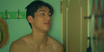 Movie still from “The Sadness” (2021), directed by Rob Jabbaz – A young shirtless man looking out of a bathroom window; Close Up shot, Low angle