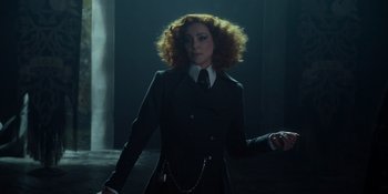 Movie still from “The School for Good and Evil” (2022), directed by Paul Feig – A woman in a suit and tie holding a chain; Medium shot, Low angle