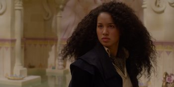 Movie still from “The School for Good and Evil” (2022), directed by Paul Feig – A woman with long black curly hair standing in front of a wall; Close Up shot, Low angle
