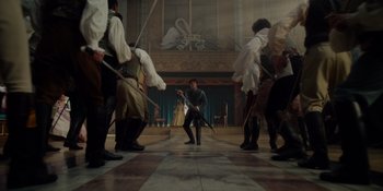 Movie still from “The School for Good and Evil” (2022), directed by Paul Feig – A group of people standing in a room holding swords; Wide shot, High angle