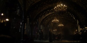 Movie still from “The School for Good and Evil” (2022), directed by Paul Feig – A group of people standing around in a room with chandeliers; Extreme Wide shot, Low angle