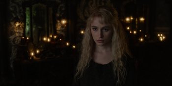 Movie still from “The School for Good and Evil” (2022), directed by Paul Feig – A woman with blonde hair is standing in a dark room; Close Up shot, Over the shoulder angle