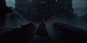 Movie still from “The School for Good and Evil” (2022), directed by Paul Feig – A man in a black cape standing in front of a building; Extreme Wide shot, Low angle