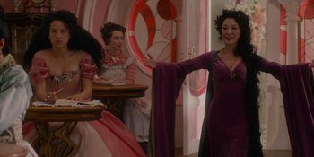 Movie still from “The School for Good and Evil” (2022), directed by Paul Feig – A woman in a purple dress standing in front of other women; Medium shot, Over the shoulder angle