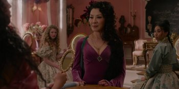 Movie still from “The School for Good and Evil” (2022), directed by Paul Feig – A woman in a purple dress holding a mirror; Medium shot, Over the shoulder angle