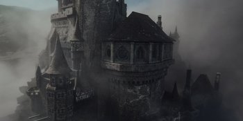 Movie still from “The School for Good and Evil” (2022), directed by Paul Feig – An old castle with a clock on the top of the tower; Extreme Wide shot, High angle