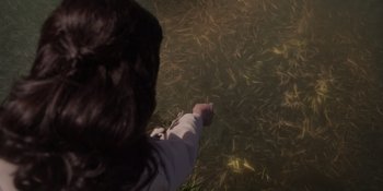 Movie still from “The School for Good and Evil” (2022), directed by Paul Feig – A person is pointing to a field of grass; Extreme Close Up shot, High angle