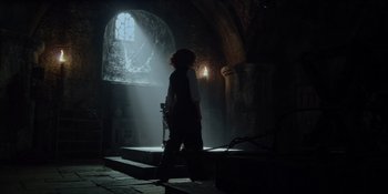 Movie still from “The School for Good and Evil” (2022), directed by Paul Feig – A person standing in a dark room with a light shining in the window; Wide shot, Low angle