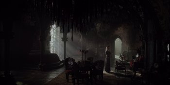 Movie still from “The School for Good and Evil” (2022), directed by Paul Feig – A person standing in a room with a table and chairs; Wide shot, High angle