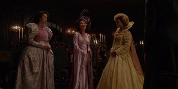 Movie still from “The School for Good and Evil” (2022), directed by Paul Feig – A group of women in fancy dresses standing in front of a fireplace; Medium shot, Low angle