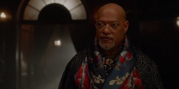 Movie still from “The School for Good and Evil” (2022), directed by Paul Feig – An older bald man wearing a colorful scarf; Close Up shot, Low angle