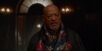 Movie still from “The School for Good and Evil” (2022), directed by Paul Feig – A bald man with glasses and a colorful scarf around his neck; Close Up shot, Low angle