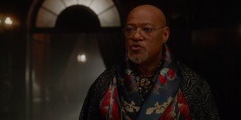 Movie still from “The School for Good and Evil” (2022), directed by Paul Feig – An older bald man wearing a colorful scarf; Close Up shot, Low angle