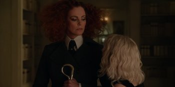 Movie still from “The School for Good and Evil” (2022), directed by Paul Feig – A woman in a suit and tie holding a pair of shears; Close Up shot, Over the shoulder angle