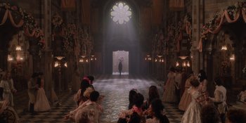 Movie still from “The School for Good and Evil” (2022), directed by Paul Feig – A group of people sitting in front of an open door; Extreme Wide shot, Over the shoulder angle