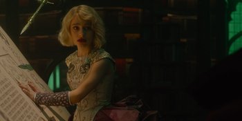 Movie still from “The School for Good and Evil” (2022), directed by Paul Feig – A woman with blonde hair sitting in front of a book shelf; Medium shot, Over the shoulder angle