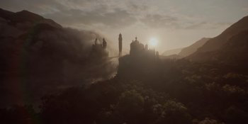 Movie still from “The School for Good and Evil” (2022), directed by Paul Feig – The sun is setting behind a castle on a hill; Extreme Wide shot, Low angle