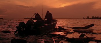 Movie still from “The Score” (2001), directed by Frank Oz – Two people in a boat on a body of water at sunset; Wide shot, Low angle