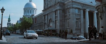Movie still from “The Score” (2001), directed by Frank Oz – People are walking down the street in front of a large building; Extreme Wide shot, High angle