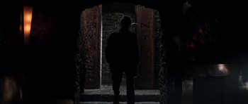 Movie still from “The Score” (2001), directed by Frank Oz – A man standing in front of an open door; Wide shot, Low angle