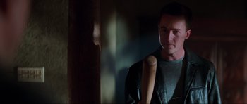 Movie still from “The Score” (2001), directed by Frank Oz – A man holding a wooden baseball bat in a room; Medium shot, Over the shoulder angle