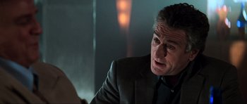 Movie still from “The Score” (2001), directed by Frank Oz – A person wearing a suit and tie; Close Up shot, Over the shoulder angle