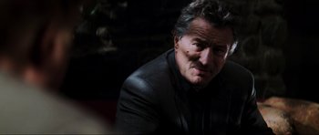 Movie still from “The Score” (2001), directed by Frank Oz – A person wearing a suit and tie; Close Up shot, Over the shoulder angle