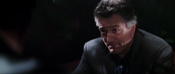 Movie still from “The Score” (2001), directed by Frank Oz – A person wearing a suit and tie; Close Up shot, Over the shoulder angle