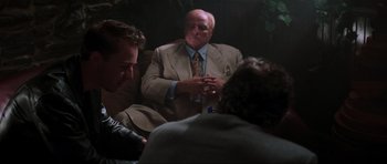 Movie still from “The Score” (2001), directed by Frank Oz – A group of people sitting around a table; Medium shot, Over the shoulder angle