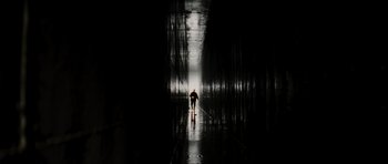 Movie still from “The Score” (2001), directed by Frank Oz – A person is walking down a wet walkway; Extreme Wide shot, Low angle