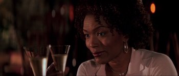 Movie still from “The Score” (2001), directed by Frank Oz – A person holding a glass of wine; Close Up shot, Over the shoulder angle