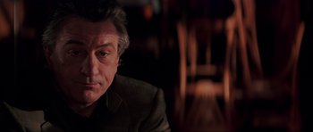 Movie still from “The Score” (2001), directed by Frank Oz – A person wearing a suit and tie; Close Up shot, Over the shoulder angle