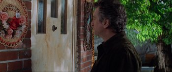 Movie still from “The Score” (2001), directed by Frank Oz – A man standing in front of a door looking into a window; Medium shot, Over the shoulder angle