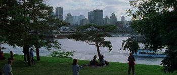 Movie still from “The Score” (2001), directed by Frank Oz – A group of people sitting under a tree near a body of water; Extreme Wide shot, High angle