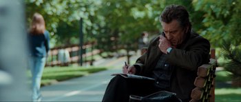 Movie still from “The Score” (2001), directed by Frank Oz – A man sitting on a bench writing on a piece of paper; Medium shot, Low angle
