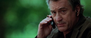 Movie still from “The Score” (2001), directed by Frank Oz – An older man talking on a cell phone outside; Close Up shot, Low angle