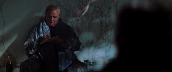 Movie still from “The Score” (2001), directed by Frank Oz – An older man sitting in front of a mirror; Medium shot, Over the shoulder angle
