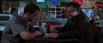 Movie still from “The Score” (2001), directed by Frank Oz – Two men sitting at a table in a restaurant; Medium shot, Over the shoulder angle