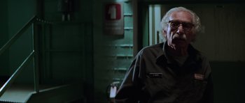Movie still from “The Score” (2001), directed by Frank Oz – An older man in a black shirt is looking at the camera; Close Up shot, Low angle