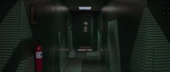 Movie still from “The Score” (2001), directed by Frank Oz – A dark hallway with a light shining on the door; Wide shot, Overhead angle