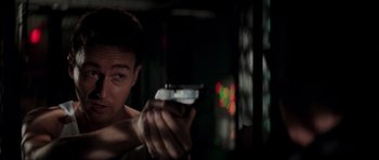 Movie still from “The Score” (2001), directed by Frank Oz – A man holding a gun in a dark room; Close Up shot, Over the shoulder angle