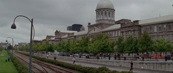 Movie still from “The Score” (2001), directed by Frank Oz – People are walking on a sidewalk near a building with a large dome on top; Extreme Wide shot, High angle