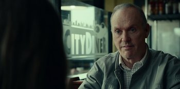 Movie still from “Dopesick” (2021), directed by Danny Strong – An older man sitting in front of a city diner sign; Close Up shot, Over the shoulder angle