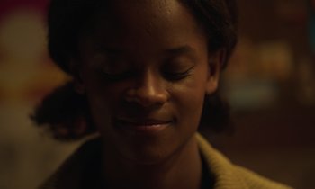 Movie still from “The Silent Twins” (2022), directed by Agnieszka Smoczynska – A person with their eyes closed; Close Up shot, Over the shoulder angle